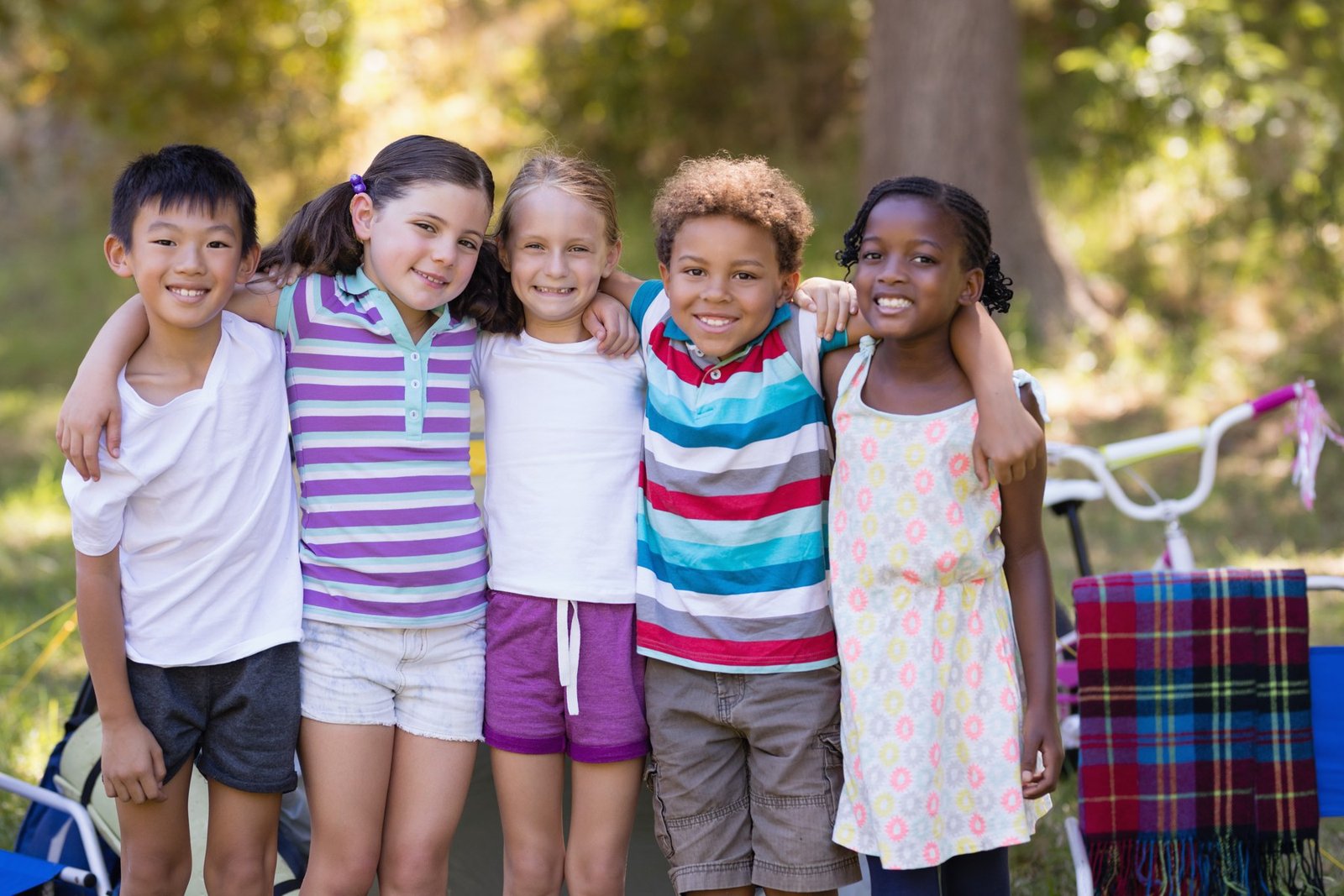Five children smiling together outdoors