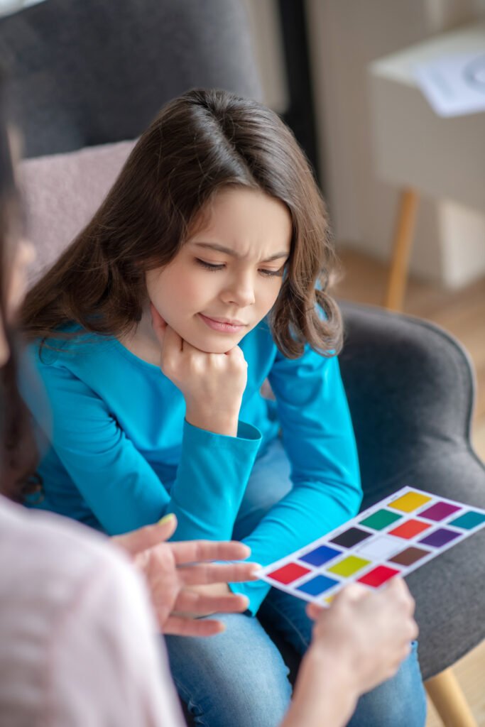 Girl looking at a colour chart with an adult.